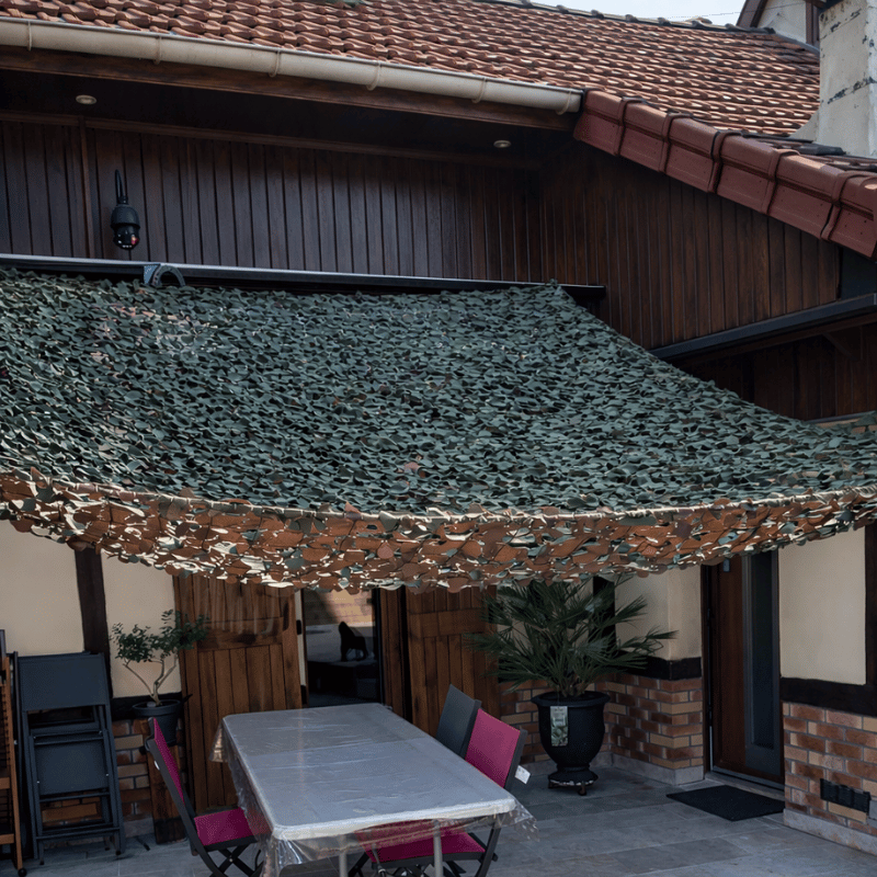 Voile d'ombrage camouflage triangulaire militaire installée sur une terrasse